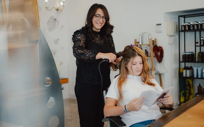 Mitarbeiterin arbeitet an Kundin und lächelt